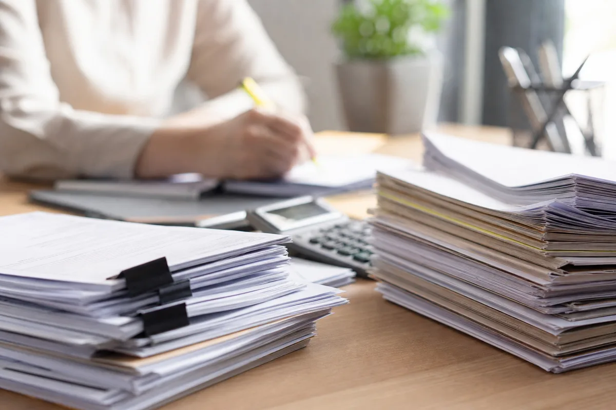 Relevés bancaires et factures triés pour établir un budget mensuel